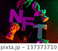 Colorful NFT letters with classical sculpture busts under vibrant neon lighting effect 137373710