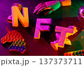 Colorful nft letters with neon pop it fidget toys and disco ball on dark surface 137373711