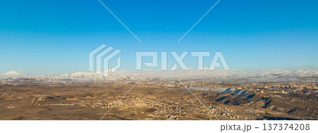 Widespread desert plain with distant mountains covered in snow Widespread desert plain with distant mountains covered in snow 137374208