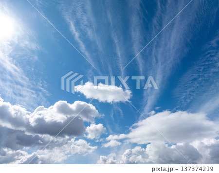 Clear, bright sky with soft white clouds drifting across deep blue canvas Clear, bright sky with soft white clouds drifting across deep blue canvas 137374219