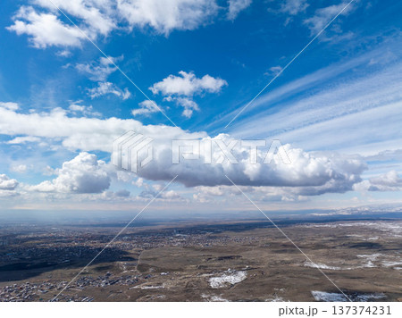 Aerial view of sprawling city under dramatic sky with scattered clouds 137374231