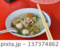 Noodle soup pork fish ball street food Asian cuisine hot bowl comforting noodle soup with pork fish ball and scallion red table 137374862