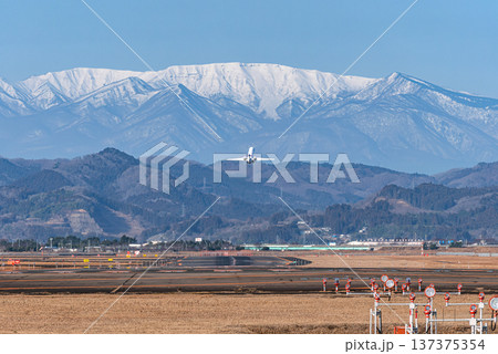 残雪の蔵王連峰に向かって仙台空港から離陸する旅客機 137375354