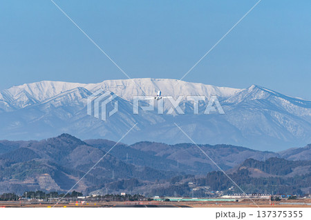 残雪の蔵王連峰に向かって仙台空港から離陸する旅客機 137375355