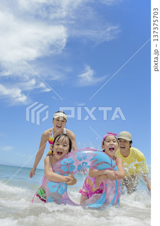 夏の海で遊ぶ4人家族 137375703