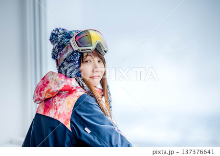 窓からスキー場のゲレンデを見る若い女性 137376641