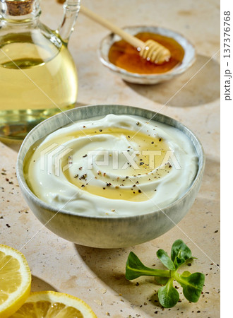 Greek yogurt bowl with honey and spices on sunny kitchen table with ingredients Greek yogurt bowl with honey and spices on sunny kitchen table with ingredients 137376768