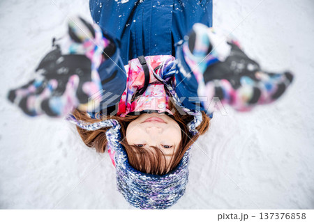 スキーウェアを着てゲレンデで雪と戯れる若い女性 スキーウェアを着てゲレンデで雪と戯れる若い女性 137376858