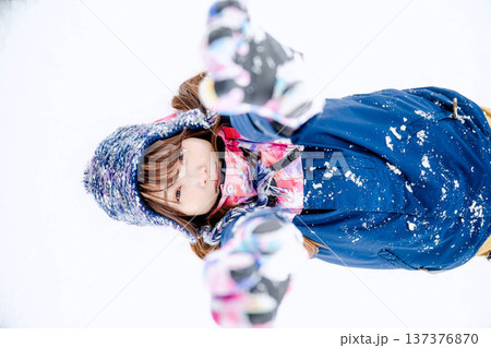 スキーウェアを着てゲレンデで雪と戯れる若い女性 スキーウェアを着てゲレンデで雪と戯れる若い女性 137376870