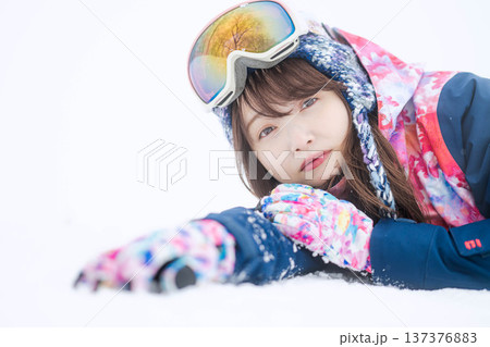 スキーウェアを着てゲレンデで雪と戯れる若い女性 スキーウェアを着てゲレンデで雪と戯れる若い女性 137376883