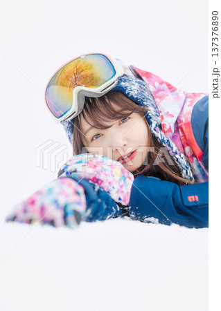 スキーウェアを着てゲレンデで雪と戯れる若い女性 スキーウェアを着てゲレンデで雪と戯れる若い女性 137376890