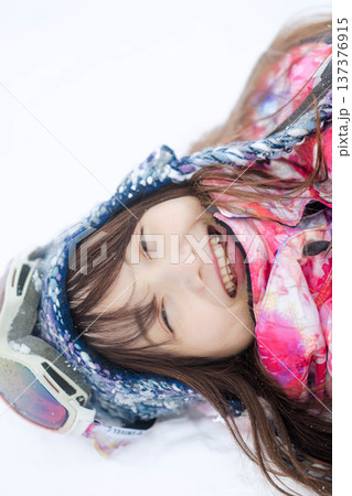 スキーウェアを着てゲレンデで雪と戯れる若い女性 スキーウェアを着てゲレンデで雪と戯れる若い女性 137376915