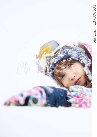 スキーウェアを着てゲレンデで雪と戯れる若い女性 137376933