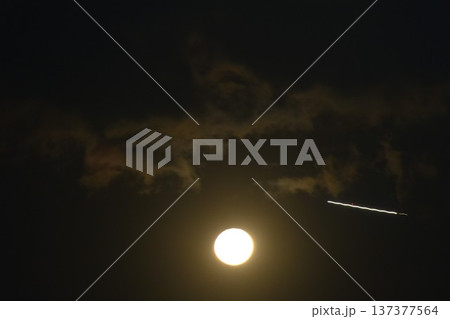 blurry air plane condensation trail light flying pass yellow full moon on sky in night blurry air plane condensation trail light flying pass yellow full moon on sky in night 137377564