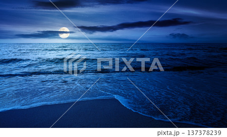 sandy sea beach background on cold summer night. low angle view. full moon over empty seascape scenery with calm waves. beauty seashore wallpaper. mysterious bay photo for advertising 137378239