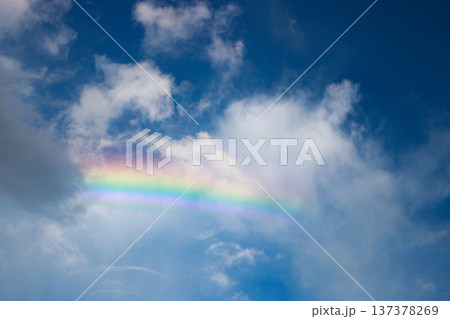 青空と白い雲にかかる鮮やかな虹 137378269