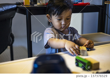Little Child Playing With Toys On His Table, A relatable and joyful photo of a little child lost in creative toy play on a table, suitable for children product and childhood lifestyle documentary. Little Child Playing With Toys On His Table, A relatable and joyful photo of a little child lost in creative toy play on a table, suitable for children product and childhood lifestyle documentary. 137378329