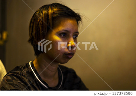 Woman Working At Screen With Light On Face, A focused woman illuminated by screen glow in a dark room, capturing modern work culture, ideal for technology and business advertising. Woman Working At Screen With Light On Face, A focused woman illuminated by screen glow in a dark room, capturing modern work culture, ideal for technology and business advertising. 137378590