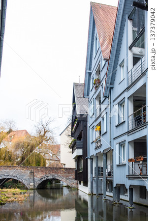 A tranquil canal in the fishermans quarter of Ulm, Germany. Reflections of colorful buildings line the water edge, creating a serene urban scene. A tranquil canal in the fishermans quarter of Ulm, Germany. Reflections of colorful buildings line the water edge, creating a serene urban scene. 137379042