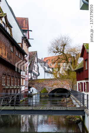A tranquil canal in the fishermans quarter of Ulm, Germany. Reflections of colorful buildings line the water edge, creating a serene urban scene. A tranquil canal in the fishermans quarter of Ulm, Germany. Reflections of colorful buildings line the water edge, creating a serene urban scene. 137379050