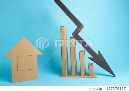 Cardboard house and chart showing decline in market trends on light blue background 137379137