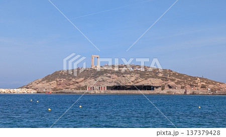 View of a small island with an ancient ruins gate on a hill between the sea and blue sky View of a small island with an ancient ruins gate on a hill between the sea and blue sky 137379428