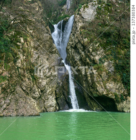 Waterfall in the mountains and lake with green water Waterfall in the mountains and lake with green water 137380384