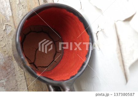 Red and black ceramic coffee cup with coffee grounds. Red and black ceramic coffee cup with coffee grounds. 137380587