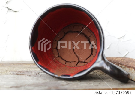 Red and black ceramic coffee cup with coffee grounds. Red and black ceramic coffee cup with coffee grounds. 137380593