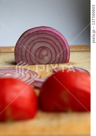 Sliced onion and sliced tomato on a cutting board. 137380603