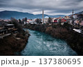 Historic Cityscape with Mosque and River Under Dramatic Sky 137380695