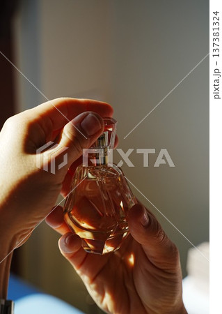 Hands Holding Perfume Bottle with Engraving 137381324