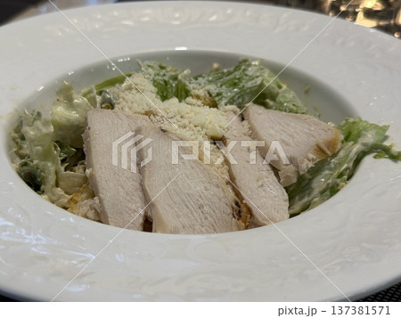 Caesar salad with sliced chicken breast, romaine lettuce, Parmesan cheese, on white plate Caesar salad with sliced chicken breast, romaine lettuce, Parmesan cheese, on white plate 137381571