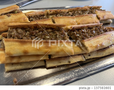 Turkish pide with minced meat filling on metallic tray in horizontal format Turkish pide with minced meat filling on metallic tray in horizontal format 137381601
