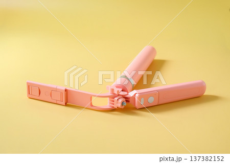 A pink selfie stick on color background. 137382152