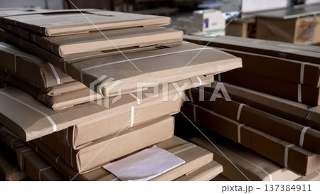 Stacks of flat-packed cardboard packages in a warehouse, concept of logistics, shipping, and supply chain. 137384911