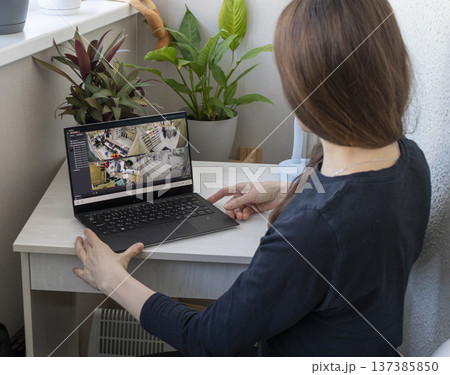 Woman monitors footage from cctv cameras on his laptop 137385850