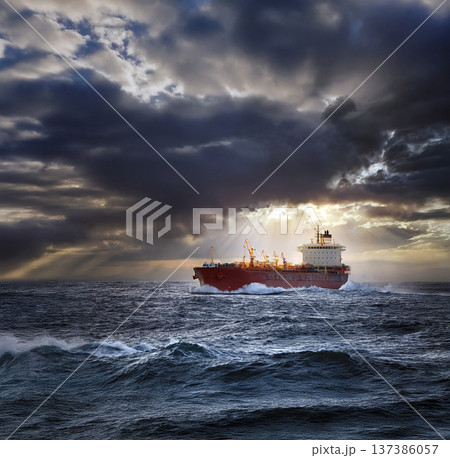 Cargo ship at sea with storm clouds at dawn Cargo ship at sea with storm clouds at dawn 137386057