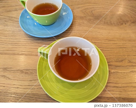 色鮮やかなカップ&ソーサーに入ったハーブティーと木目調のテーブルの風景 色鮮やかなカップ&ソーサーに入ったハーブティーと木目調のテーブルの風景 137386070