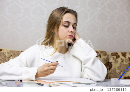 Young female artist is upset with her work. Poor drawing has upset artist. Artist painting turned out ugly. Emotions of disappointment. Concept of despair and dissatisfaction with work done Young female artist is upset with her work. Poor drawing has upset artist. Artist painting turned out ugly. Emotions of disappointment. Concept of despair and dissatisfaction with work done 137386113