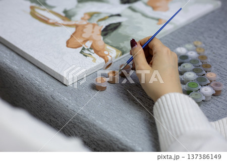 Compact painting kit to take with you. Girl pulled out her kit with small paint jars and is ready to paint small picture. Travel with hobby and ability to take everything you need for painting 137386149