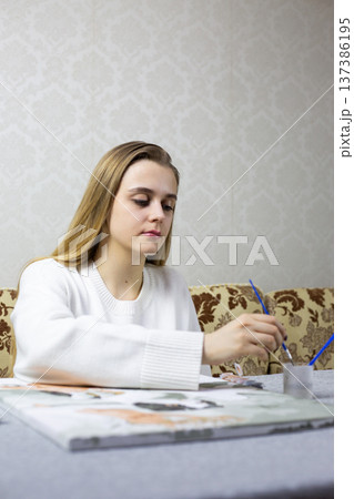 Young woman paints picture for competition. The process of creating painting for exhibition and competition for the best painting. Tournament for artists that requires best work on specific topic Young woman paints picture for competition. The process of creating painting for exhibition and competition for the best painting. Tournament for artists that requires best work on specific topic 137386195