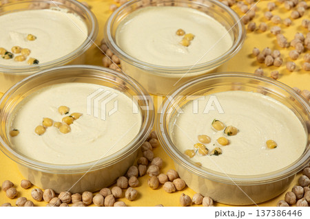 Hummus bowls with whole chickpeas on yellow background. 137386446