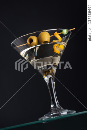 Classic Martini with Olives and Lemon Twist on Dark Background. Elegant Cocktail Composition 137386494