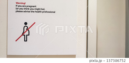 A medical warning sign is a pictogram of a pregnant woman with a red diagonal line through it and warning text. Concept: safety protocols in healthcare, hospital signs. A medical warning sign is a pictogram of a pregnant woman with a red diagonal line through it and warning text. Concept: safety protocols in healthcare, hospital signs. 137386752