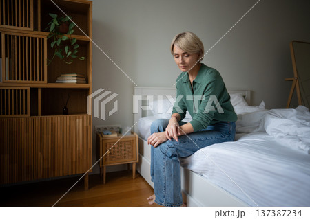 Unmotivated tired woman sitting on bed showing signs of apathy and burn out, personal life crisis. Unmotivated tired woman sitting on bed showing signs of apathy and burn out, personal life crisis. 137387234