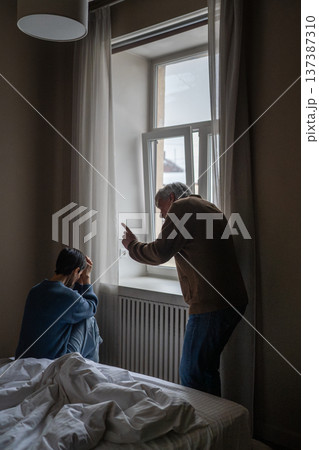 Domestic verbal violence and abuse, exhausted female being verbally attacked by irritated man. Domestic verbal violence and abuse, exhausted female being verbally attacked by irritated man. 137387310