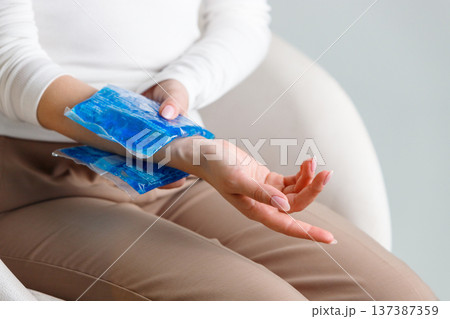 woman applying cold compress to painful wrist. Carpal tunnel syndrome 137387359