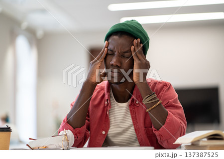 Exhausted black student man suffering from anxiety or panic attack after long prepare exam on laptop 137387525