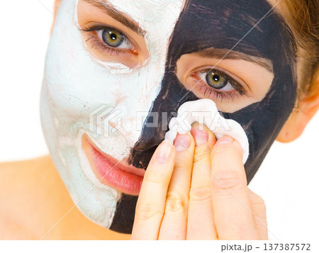 Girl remove black white mud mask from face Girl remove black white mud mask from face 137387572